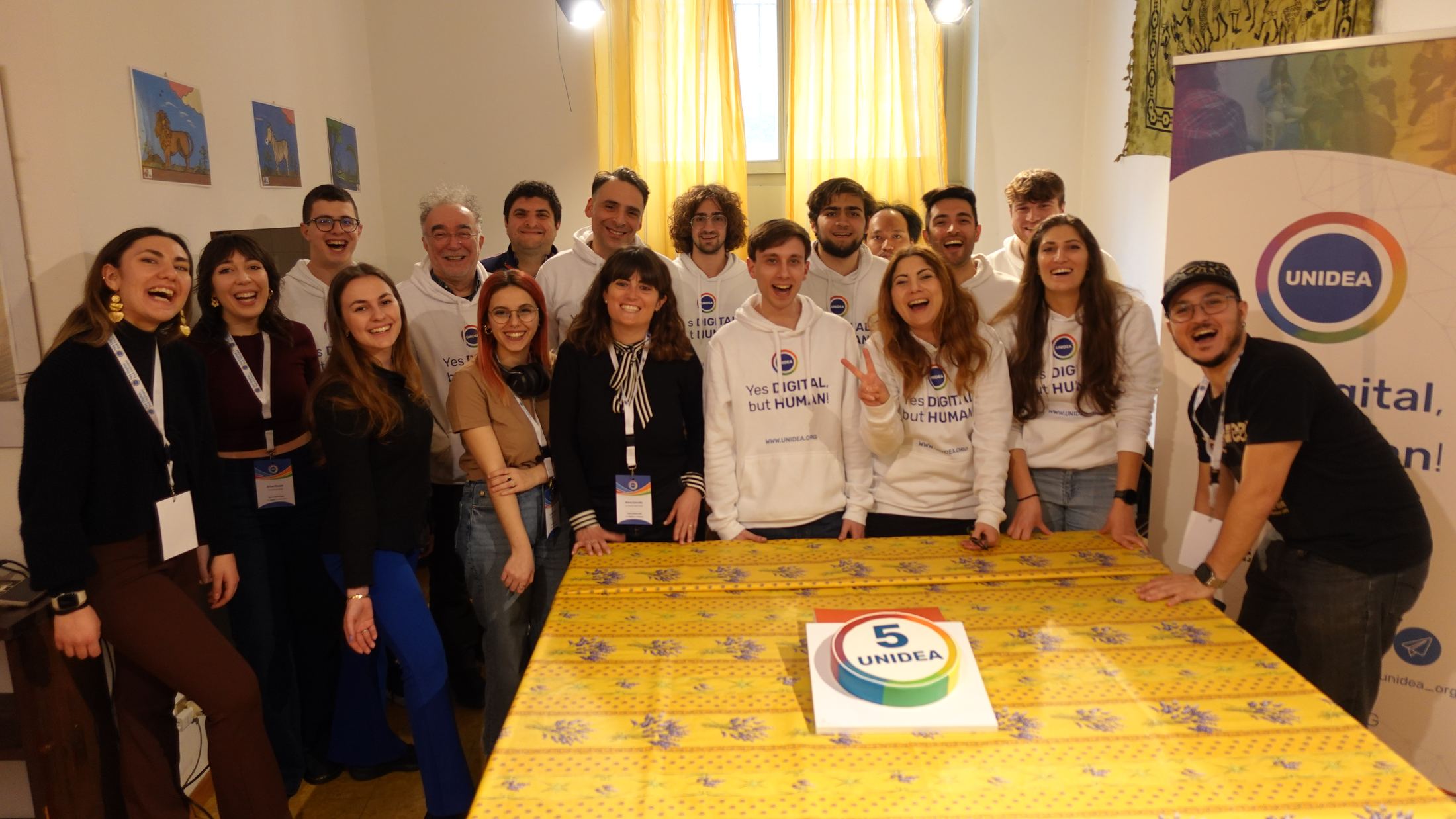 Il team di volontari UNIDEA sorride insieme durante la festa per il quinto anniversario dell'associazione
